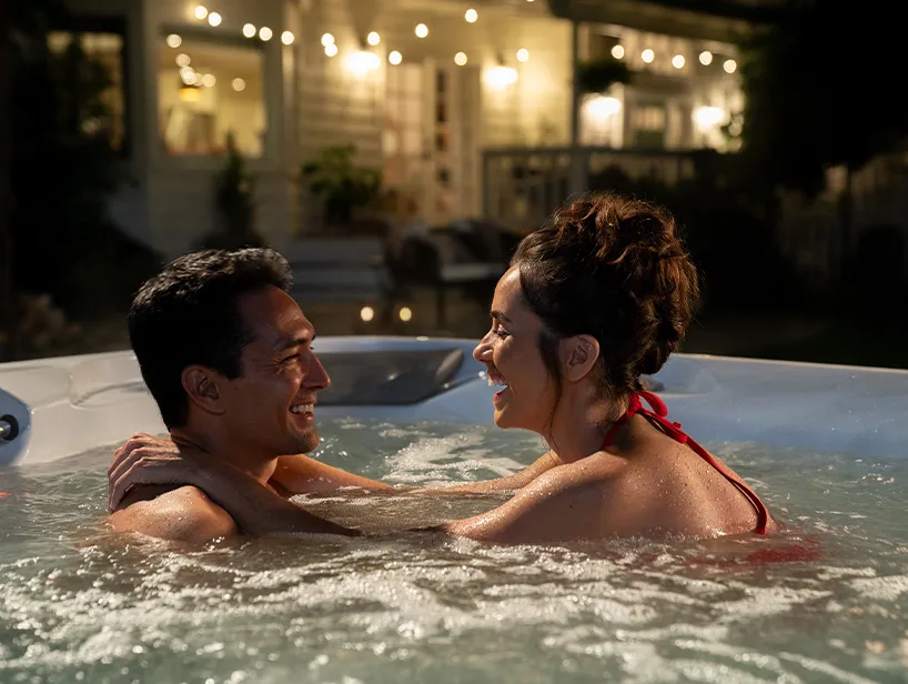 Paar badet abends im angenehm beheizten Whirlpool – stimmungsvolle Nutzung dank durchdachter Whirlpool-Heiztechnik.