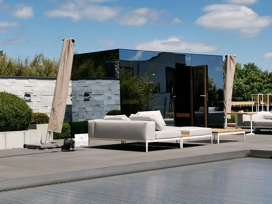 Moderne Gartensauna TALO neben Pool und Lounge-Möbeln auf einer Terrasse