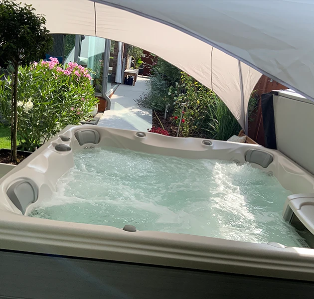 Whirlpool Sundance 780 Hamilton bei einer Kundin im Garten unter einem Sonnensegel