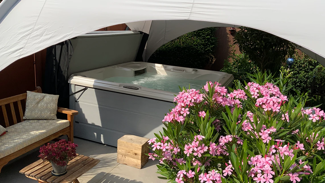 Whirlpool Sundance 780 Hamilton bei einer Kundin im Garten unter einem Sonnensegel